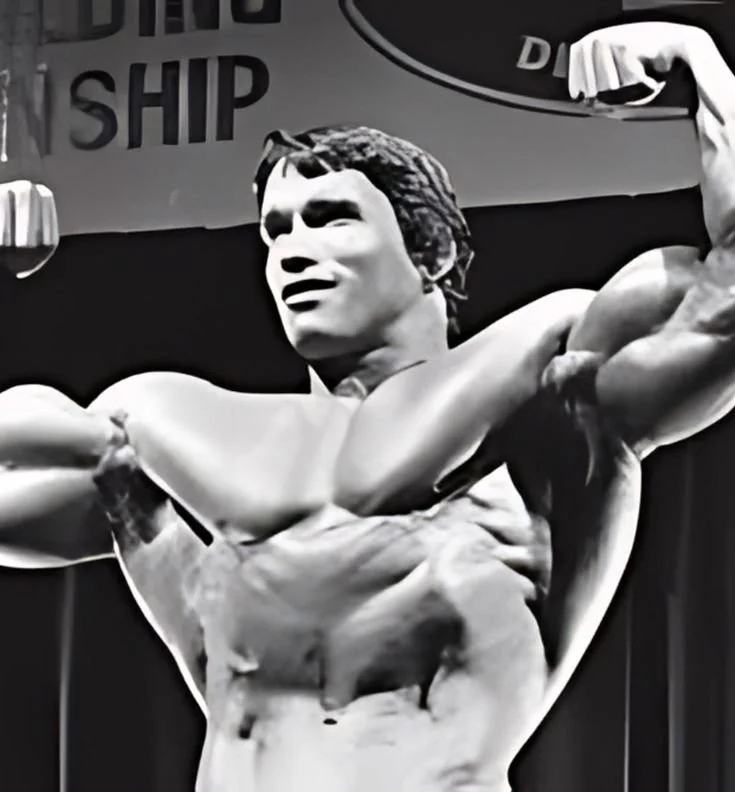 Arnold Schwarzenegger demonstrating preacher curls for bigger biceps